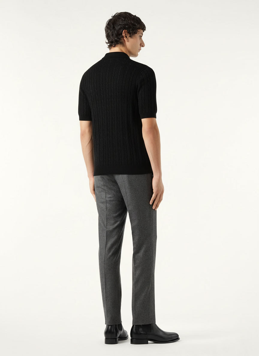 Man wearing a black sweater and gray pants on a white background
