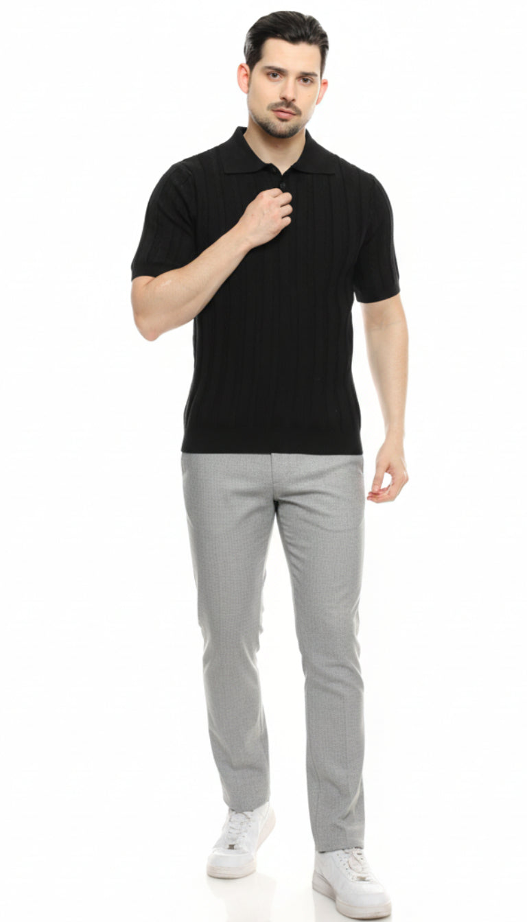 Man wearing a black polo shirt and gray pants on a white background