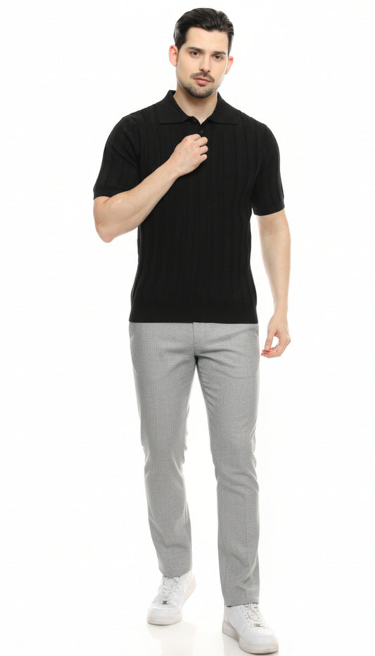 Man wearing a black polo shirt and gray pants on a white background