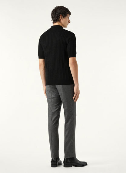 Man wearing a black sweater and gray pants on a white background